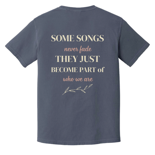 Vintage-inspired back print on the color Denim Comfort Colors t-shirt featuring the quote "Some Songs Never Fade They Just Become Part of Who We Are" with elegant typography and botanical accent. 