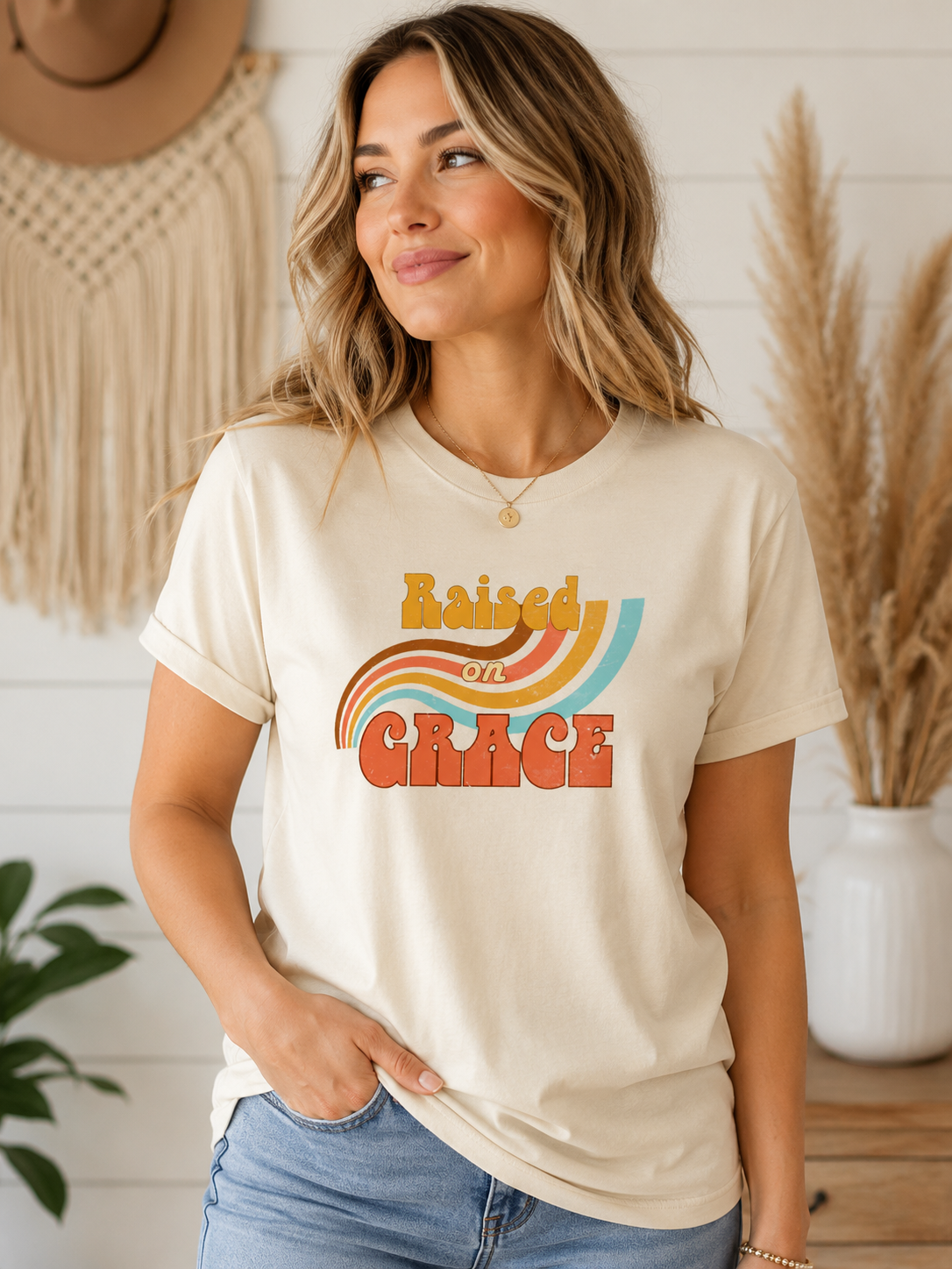 Woman wearing cream Raised on Grace distressed vintage graphic tee featuring retro typography and a worn-in nostalgic design on a Bella + Canvas shirt