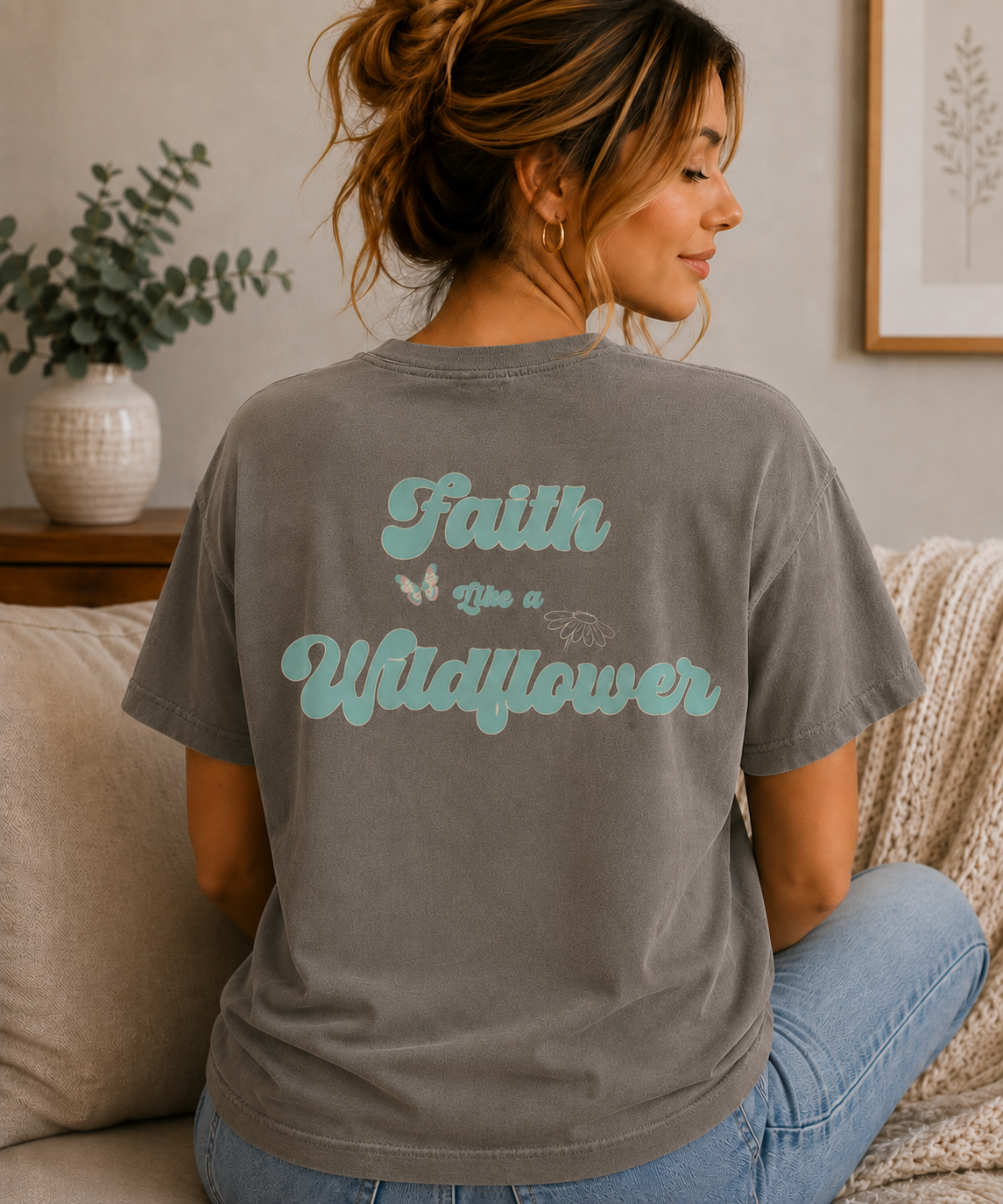Back view of a woman wearing a Pepper Comfort Colors T-shirt with a large Faith Like a Wildflower graphic.