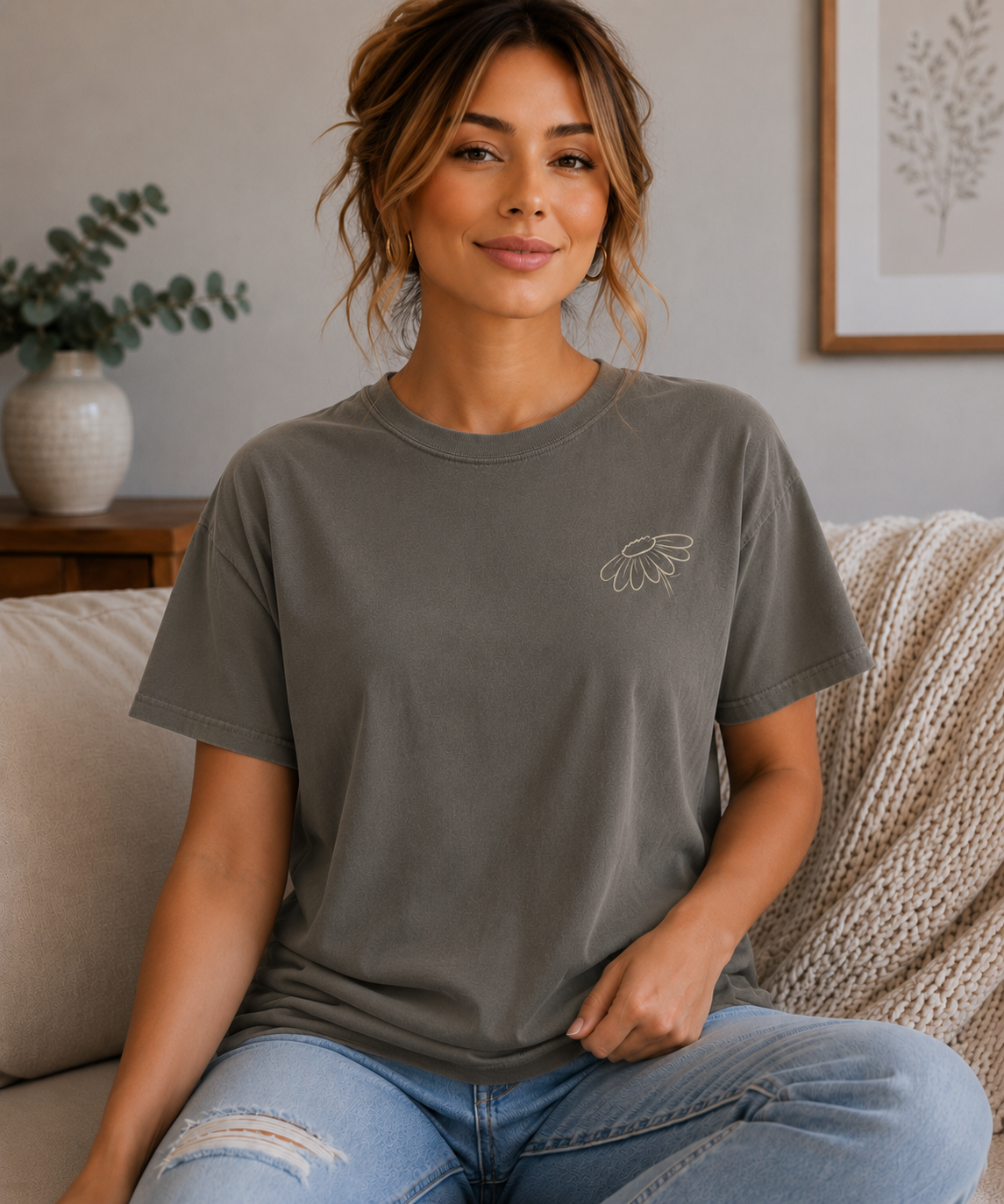 Woman wearing a Pepper Comfort Colors T-shirt with a small cream wildflower design on the front left chest.