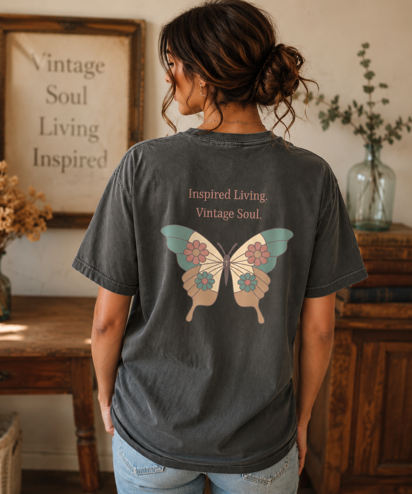 Comfort Colors Pepper t-shirt featuring the Inspired Living Vintage Soul butterfly design on the back, shown on a woman in a warm vintage-inspired setting. Signature Vintage Collection graphic tee with coordinating left chest detail.