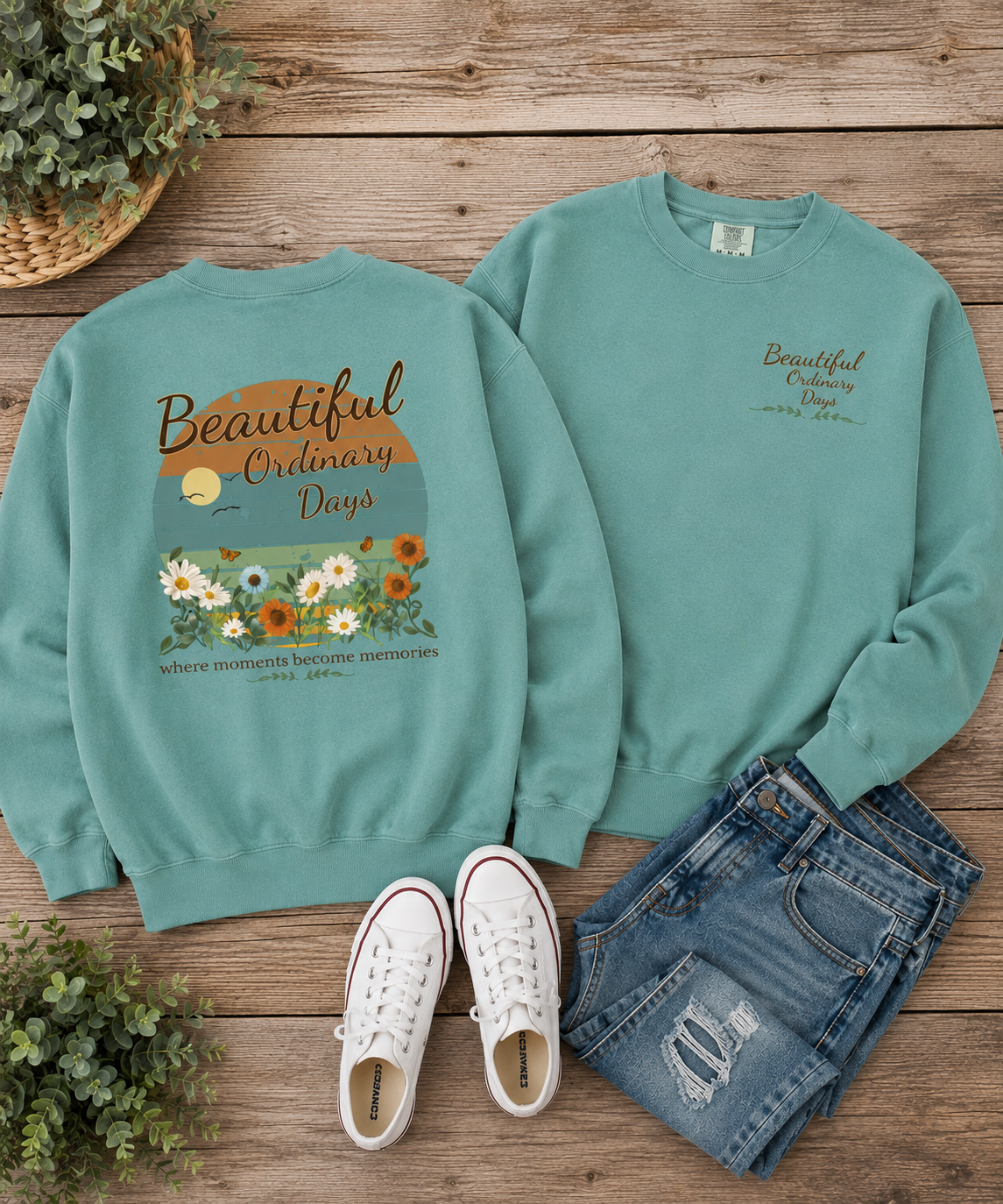 Flat lay mockup of a seafoam green Comfort Colors crewneck sweatshirt featuring the Beautiful Ordinary Days floral back print and matching left chest design with denim jeans and white sneakers.