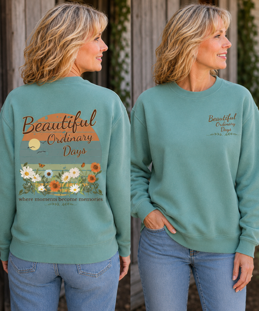 Mature woman wearing a seafoam green Comfort Colors crewneck sweatshirt with Beautiful Ordinary Days floral back print and matching left chest design.