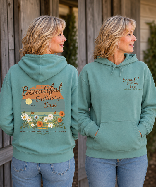 Lifestyle mockup of a seafoam green Comfort Colors hoodie featuring the Beautiful Ordinary Days floral back print and chest logo.