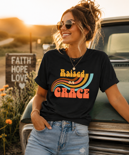 Woman wearing a black retro “Raised on Grace” Raised on Grace soulful vintage graphic tee featuring retro-inspired typography and faith-inspired message on a Bella + Canvas unisex shirt