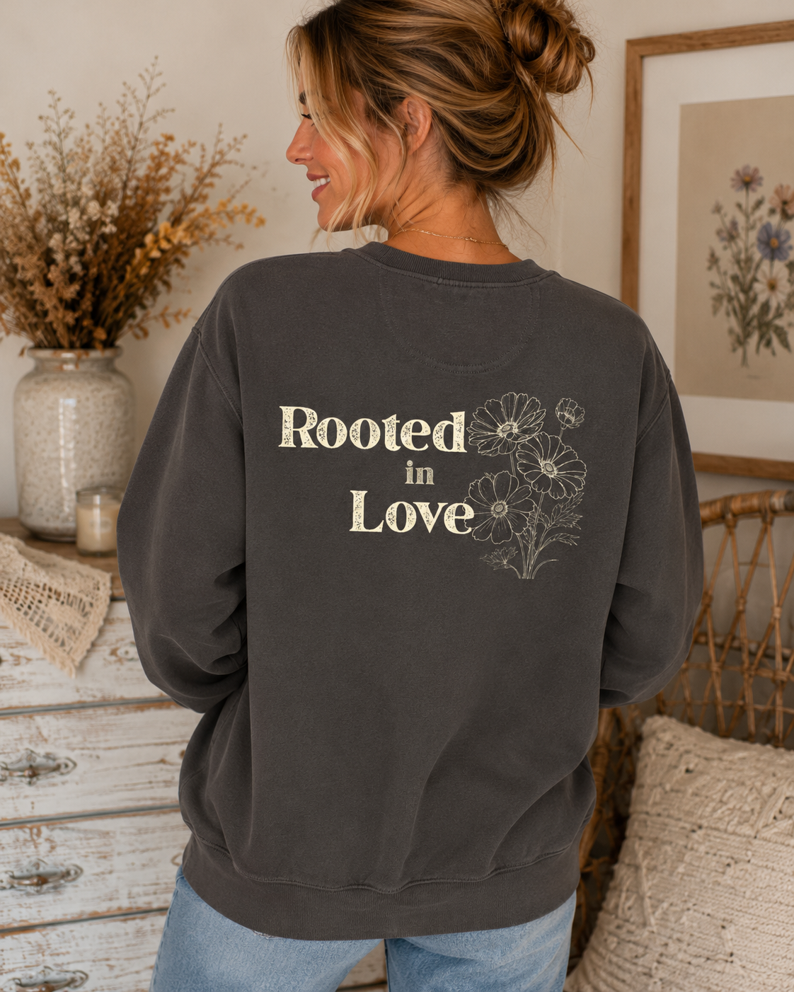 
Back view of Comfort Colors Pepper crewneck sweatshirt featuring large Rooted in Love floral graphic in a warm vintage home setting.